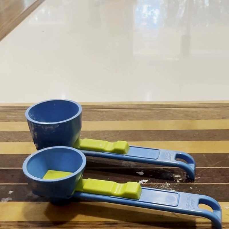 The Slide Scoop's two scoops, one and two tablespoons, on a cutting board